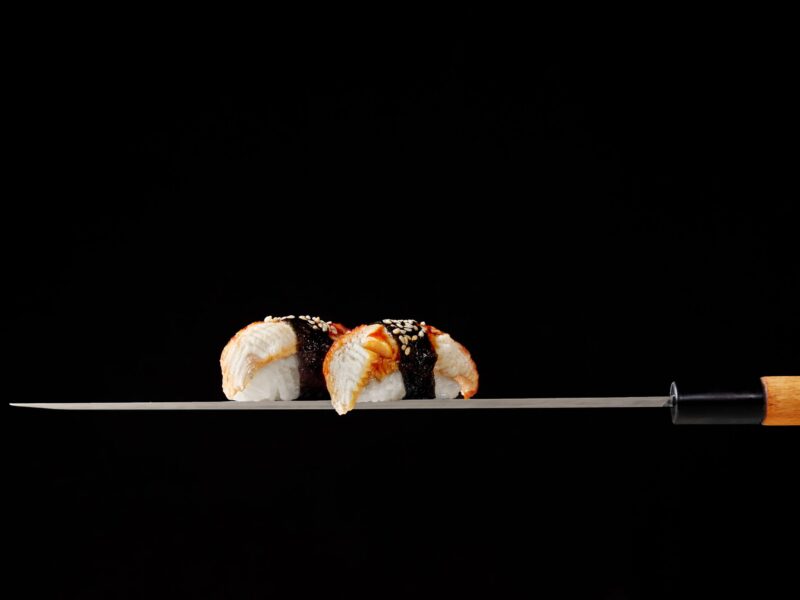 nigiri-sushi-with-eel-served-blade-traditional-japanese-knife-black-background-scaled