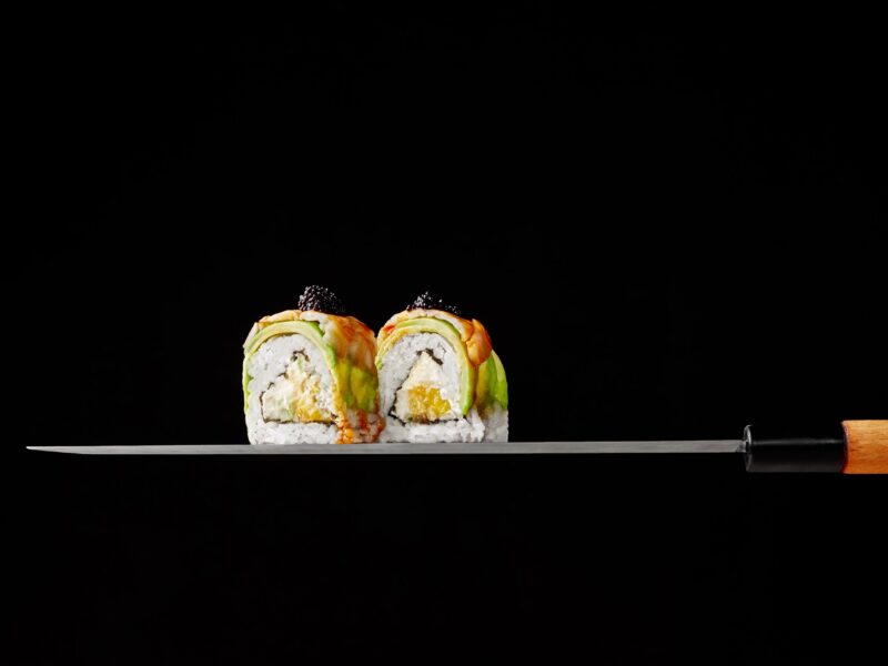 two-uramaki-rolls-with-cream-cheese-mango-avocado-shrimps-blade-japanese-knife-black-ba-scaled
